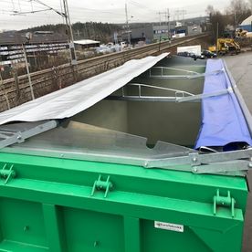 Grønn lastebilhenger på parkeringsplass